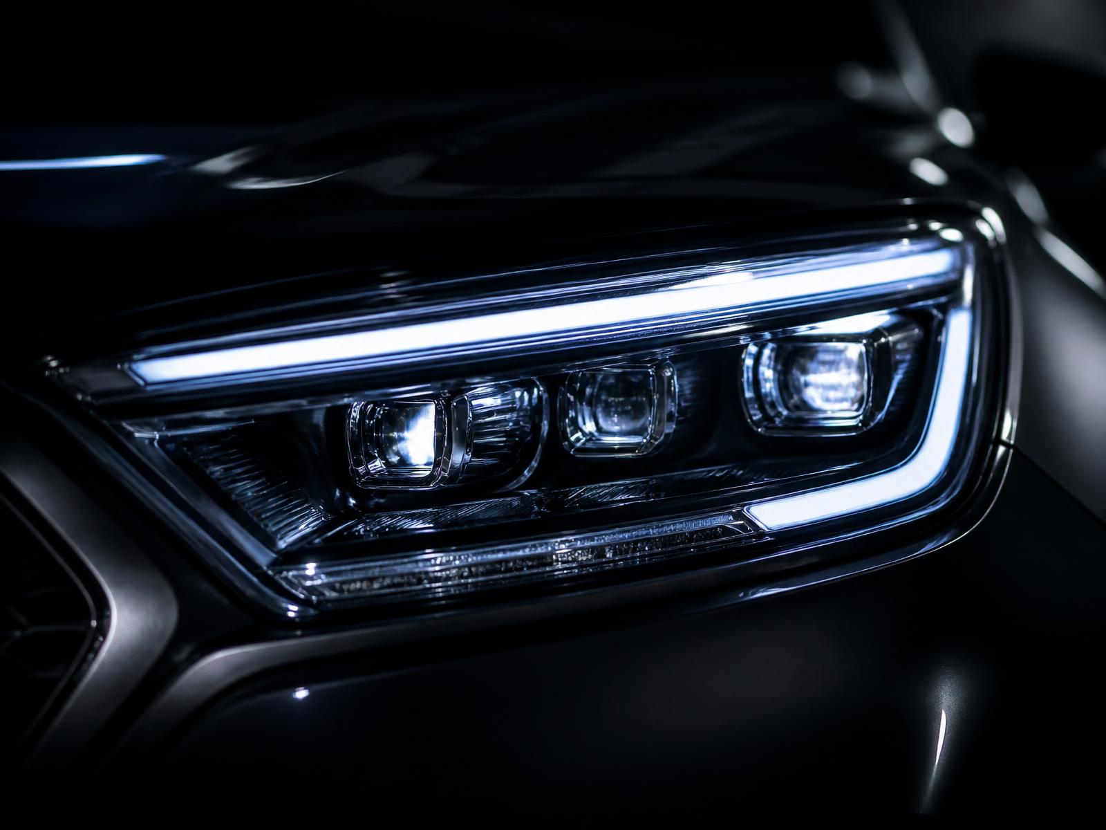 Close-up of a clear, restored vehicle headlight at night